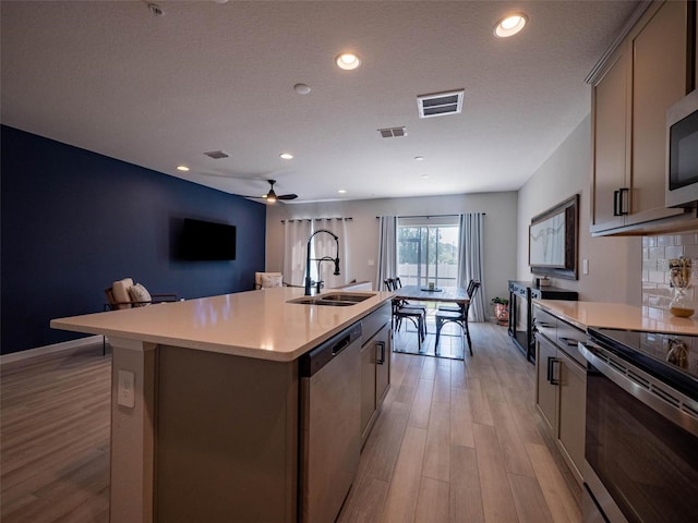 391 Cape Honeysuckle Pl, Sanford, FL 32771 - kitchen featuring stainless steel appliances, a sink, light wood finished floors, light countertops, and recessed lighting