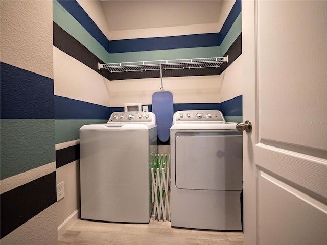 391 Cape Honeysuckle Pl, Sanford, FL 32771 - laundry room with washer and clothes dryer, wood finished floors, and a textured wall