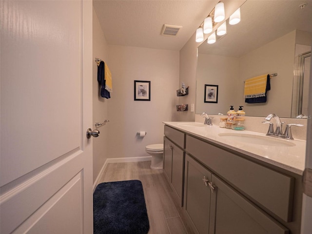 391 Cape Honeysuckle Pl, Sanford, FL 32771 - full bathroom with toilet, double vanity, baseboards, wood finished floors, and an enclosed shower