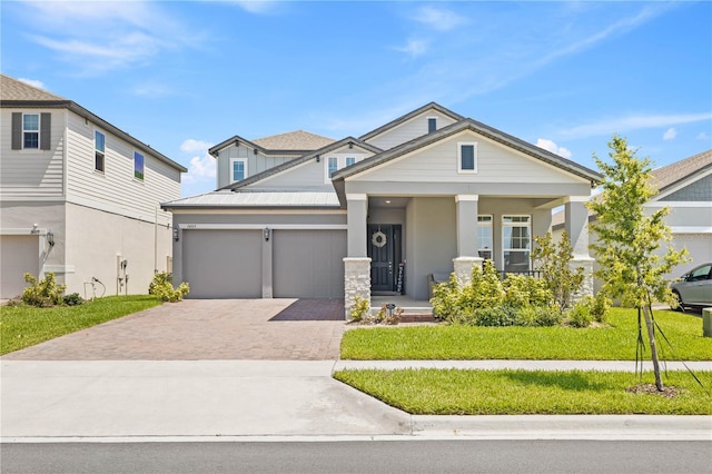 16013 Silver Brook Way, Winter Garden, FL 34787 - craftsman-style home featuring decorative driveway, a front lawn, a garage, covered porch, and stucco siding
