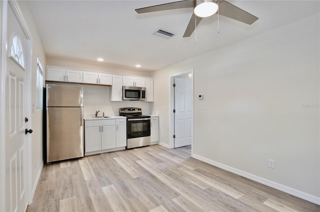 222 E Atwater Ave, Eustis, FL 32726 - kitchen featuring stainless steel appliances, a sink, a ceiling fan, white cabinetry, and baseboards