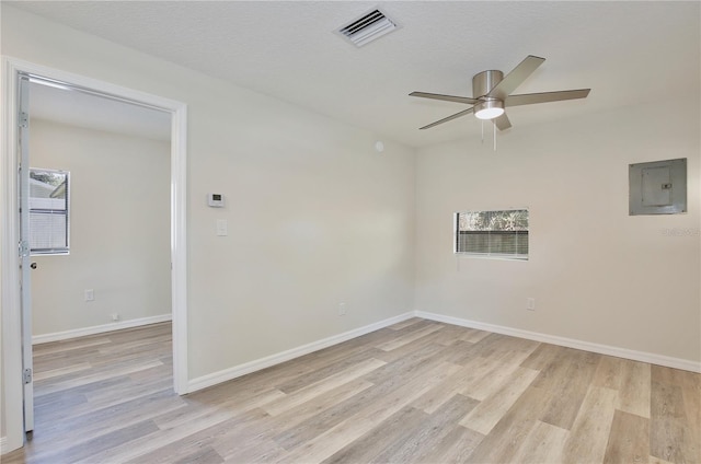 222 E Atwater Ave, Eustis, FL 32726 - empty room with electric panel, light wood-type flooring, ceiling fan, and healthy amount of natural light