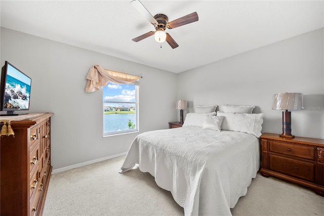 2332 Andrews Valley Dr, Kissimmee, FL 34758 - bedroom with light carpet, baseboards, a ceiling fan, and a water view