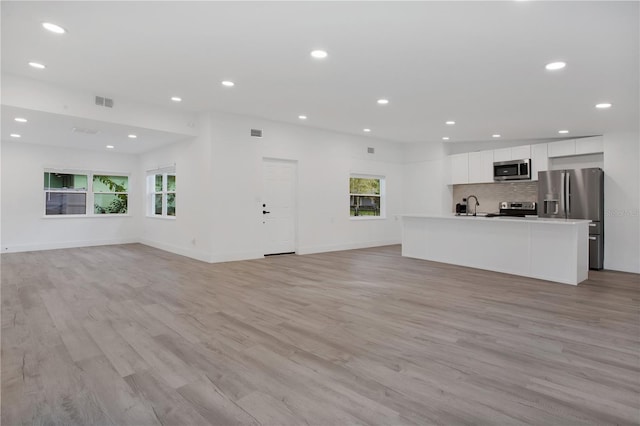 4201 Mizell St, Orlando, FL 32812 - unfurnished living room with healthy amount of natural light, light wood-type flooring, recessed lighting, and baseboards