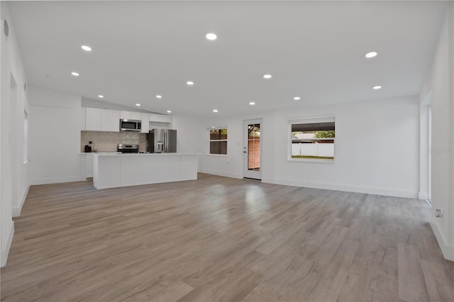 4201 Mizell St, Orlando, FL 32812 - unfurnished living room featuring recessed lighting, baseboards, and light wood finished floors