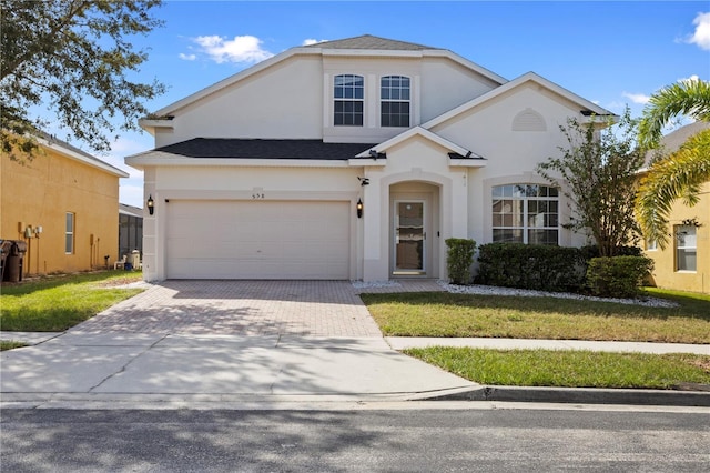 558 Cadiz Loop, Davenport, FL 33837 - traditional home with stucco siding, decorative driveway, a garage, and a front lawn
