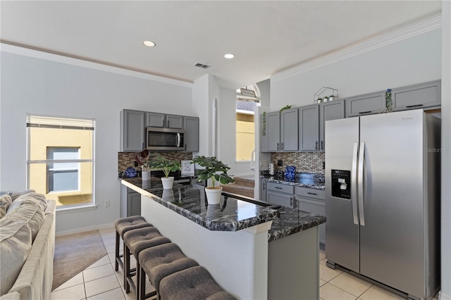 558 Cadiz Loop, Davenport, FL 33837 - kitchen with appliances with stainless steel finishes, gray cabinets, light tile patterned floors, tasteful backsplash, and dark stone counters