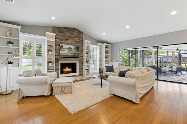 1327 Bridgeport Dr, Winter Park, FL 32789 - living area featuring light wood-style flooring, vaulted ceiling, healthy amount of natural light, a stone fireplace, and recessed lighting