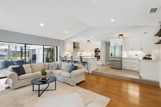 1327 Bridgeport Dr, Winter Park, FL 32789 - living area featuring vaulted ceiling and light wood-style floors