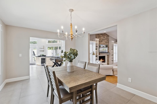 1327 Bridgeport Dr, Winter Park, FL 32789 - dining area with beverage cooler, a chandelier, light tile patterned floors, and a fireplace