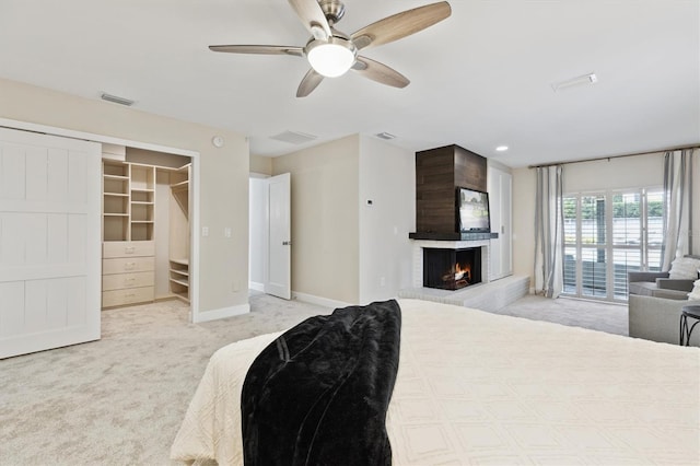 1327 Bridgeport Dr, Winter Park, FL 32789 - bedroom with light carpet, a fireplace, ceiling fan, and a walk in closet