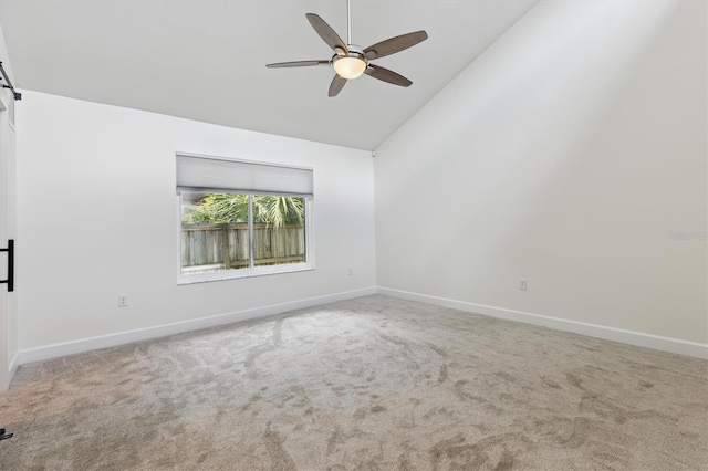 1327 Bridgeport Dr, Winter Park, FL 32789 - carpeted empty room with a ceiling fan, high vaulted ceiling, and a barn door