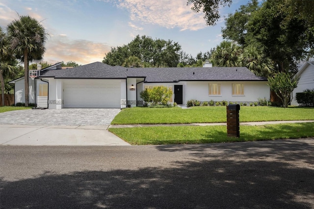 1327 Bridgeport Dr, Winter Park, FL 32789 - single story home featuring decorative driveway, an attached garage, a front yard, a chimney, and stucco siding