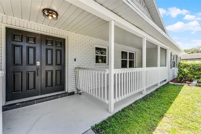 174 Pine Grove Ct, Daytona Beach, FL 32119 - doorway to property with covered porch and brick siding