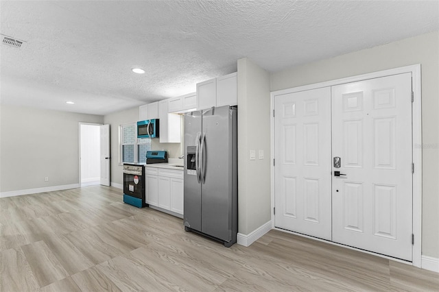 174 Pine Grove Ct, Daytona Beach, FL 32119 - kitchen with stainless steel appliances, a textured ceiling, white cabinets, baseboards, and recessed lighting