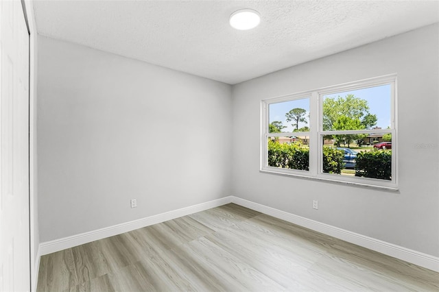 174 Pine Grove Ct, Daytona Beach, FL 32119 - unfurnished room featuring light wood-style flooring, baseboards, and a textured ceiling