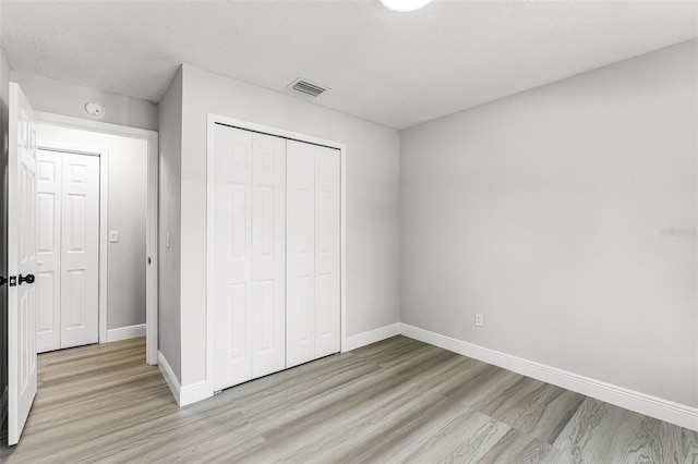 174 Pine Grove Ct, Daytona Beach, FL 32119 - unfurnished bedroom with light wood finished floors, baseboards, and a closet