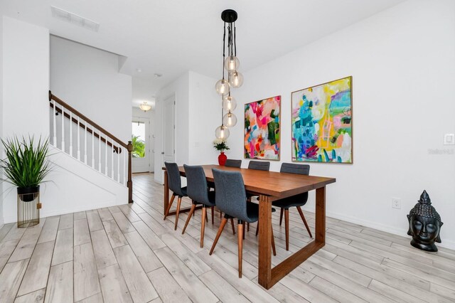 652 Benoi Dr, Davenport, FL 33896 - dining room with light wood-type flooring, stairway, and baseboards