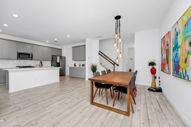 652 Benoi Dr, Davenport, FL 33896 - dining area with light wood-type flooring, stairs, recessed lighting, and baseboards