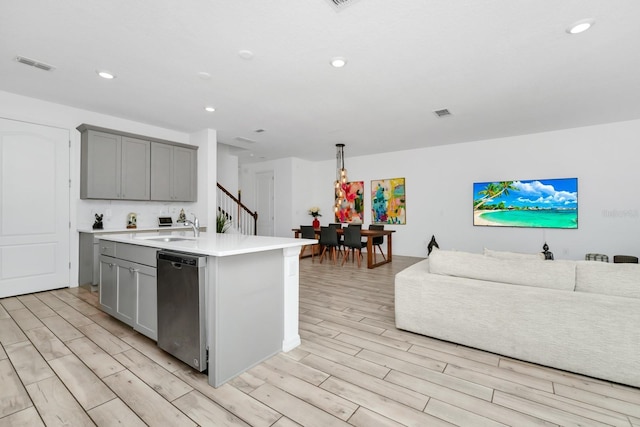652 Benoi Dr, Davenport, FL 33896 - kitchen with gray cabinetry, dishwasher, light wood-style floors, open floor plan, and light countertops