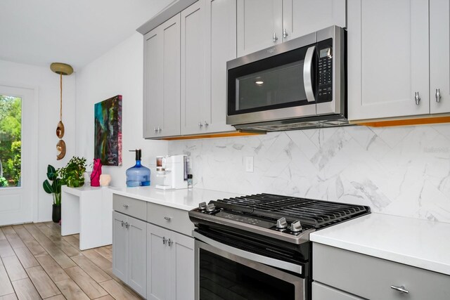 652 Benoi Dr, Davenport, FL 33896 - kitchen with appliances with stainless steel finishes, gray cabinetry, backsplash, and light countertops