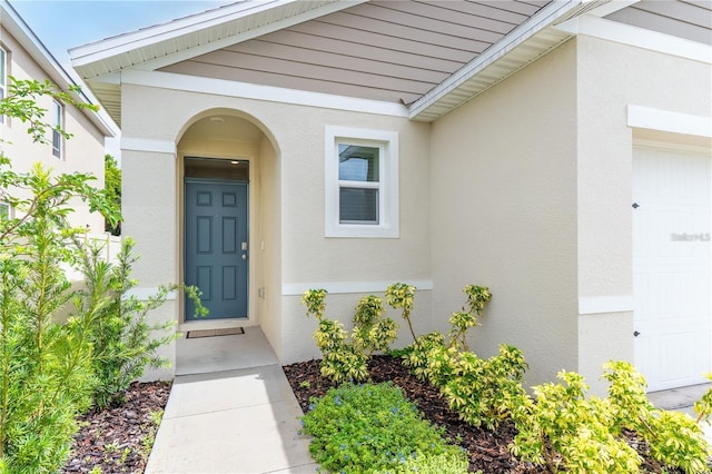1267 Berry Ln, Davenport, FL 33837 - view of exterior entry with stucco siding and an attached garage