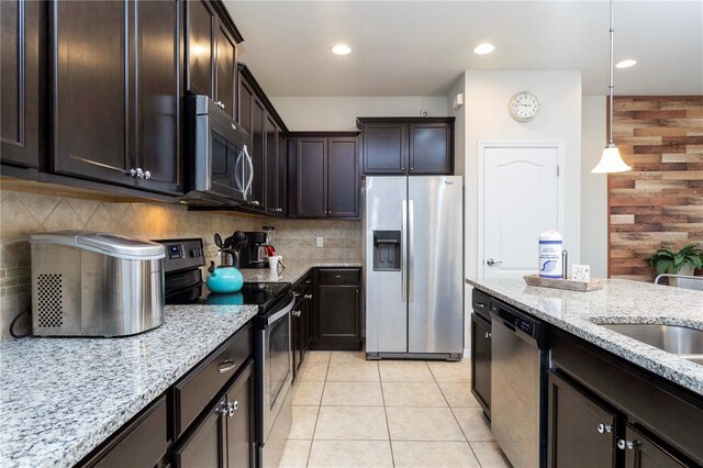 1979 Majorca Dr, Kissimmee, FL 34747 - kitchen with stainless steel appliances, light stone counters, light tile patterned floors, dark brown cabinets, and decorative backsplash