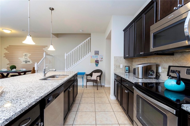1979 Majorca Dr, Kissimmee, FL 34747 - kitchen with appliances with stainless steel finishes, a sink, tasteful backsplash, light tile patterned floors, and pendant lighting
