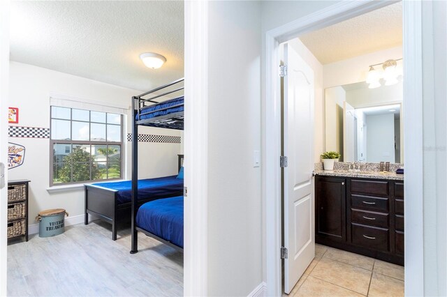1979 Majorca Dr, Kissimmee, FL 34747 - bedroom with baseboards, a textured ceiling, and a sink