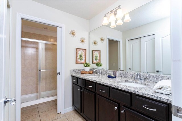 1979 Majorca Dr, Kissimmee, FL 34747 - bathroom with a shower stall, double vanity, tile patterned floors, a chandelier, and baseboards