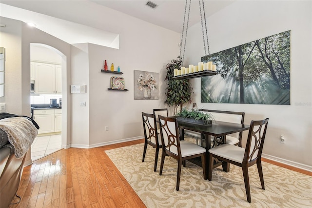 404 Sotheby Way, Debary, FL 32713 - dining room with light wood finished floors, arched walkways, and baseboards