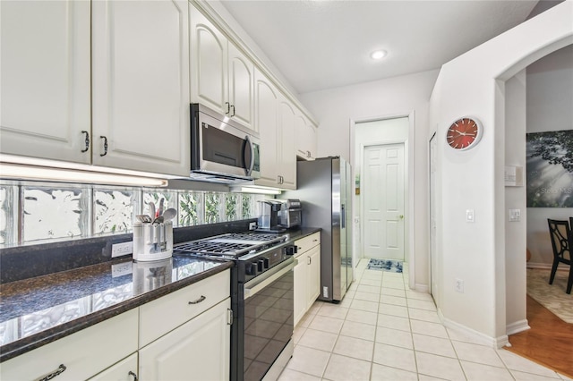 404 Sotheby Way, Debary, FL 32713 - kitchen featuring appliances with stainless steel finishes, light tile patterned floors, arched walkways, white cabinets, and recessed lighting