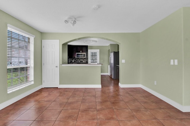 416 Banyon Tree Cir Unit 108, Maitland, FL 32751 - kitchen with appliances with stainless steel finishes, healthy amount of natural light, tile patterned floors, and backsplash