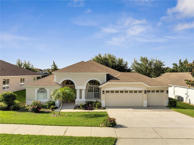 10955 Lemay Dr, Clermont, FL 34711 - mediterranean / spanish home featuring an attached garage, concrete driveway, a front yard, stucco siding, and a shingled roof