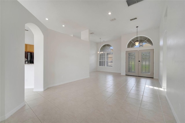 10955 Lemay Dr, Clermont, FL 34711 - unfurnished room featuring light tile patterned flooring, recessed lighting, french doors, a chandelier, and arched walkways