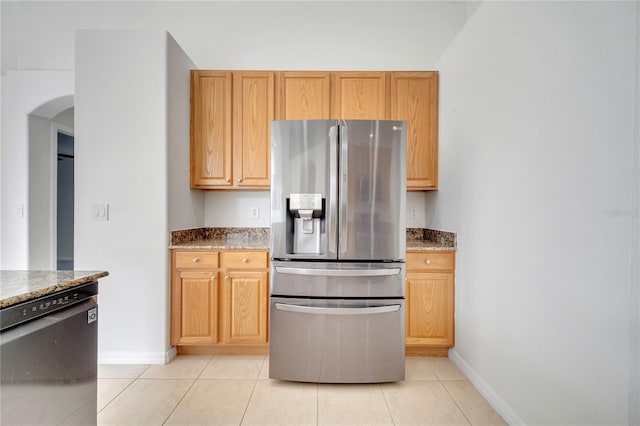 10955 Lemay Dr, Clermont, FL 34711 - kitchen featuring stainless steel appliances, arched walkways, light tile patterned flooring, and stone counters