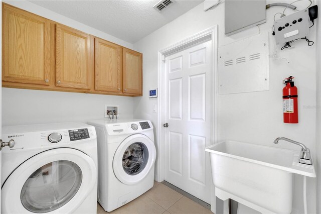 10955 Lemay Dr, Clermont, FL 34711 - washroom featuring cabinet space, separate washer and dryer, light tile patterned floors, and a textured ceiling