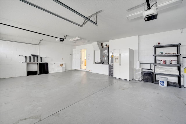 10955 Lemay Dr, Clermont, FL 34711 - garage featuring a garage door opener, white fridge with ice dispenser, and concrete block wall