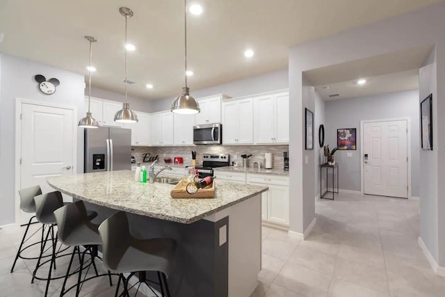 271 Jetty Way, Davenport, FL 33897 - kitchen with appliances with stainless steel finishes, decorative backsplash, a breakfast bar area, white cabinetry, and recessed lighting