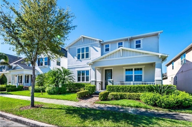 14753 Snowy Egret St, Winter Garden, FL 34787 - view of front facade featuring covered porch, a front yard, stucco siding, and board and batten siding