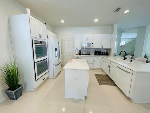 14753 Snowy Egret St, Winter Garden, FL 34787 - kitchen with a sink, white appliances, a kitchen island, white cabinetry, and recessed lighting