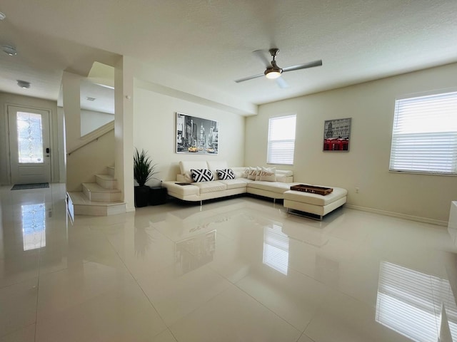 14753 Snowy Egret St, Winter Garden, FL 34787 - living room featuring tile patterned floors, ceiling fan, stairway, baseboards, and a textured ceiling