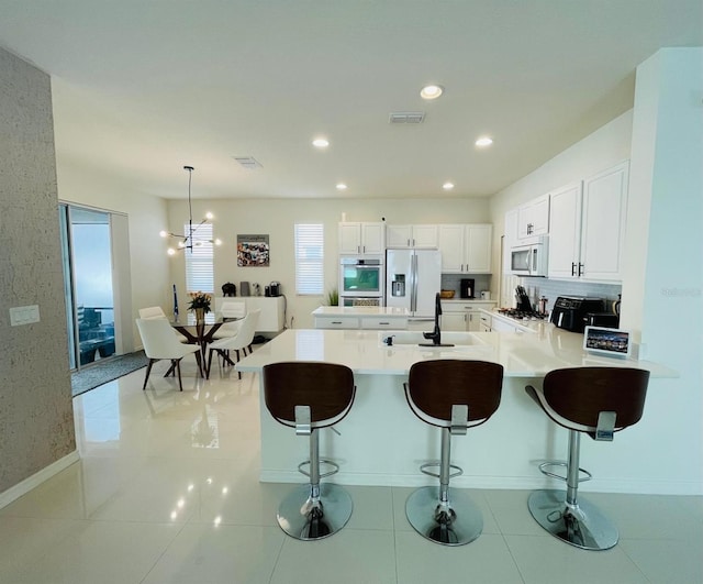 14753 Snowy Egret St, Winter Garden, FL 34787 - kitchen featuring white microwave, fridge with ice dispenser, a sink, a peninsula, and a breakfast bar area