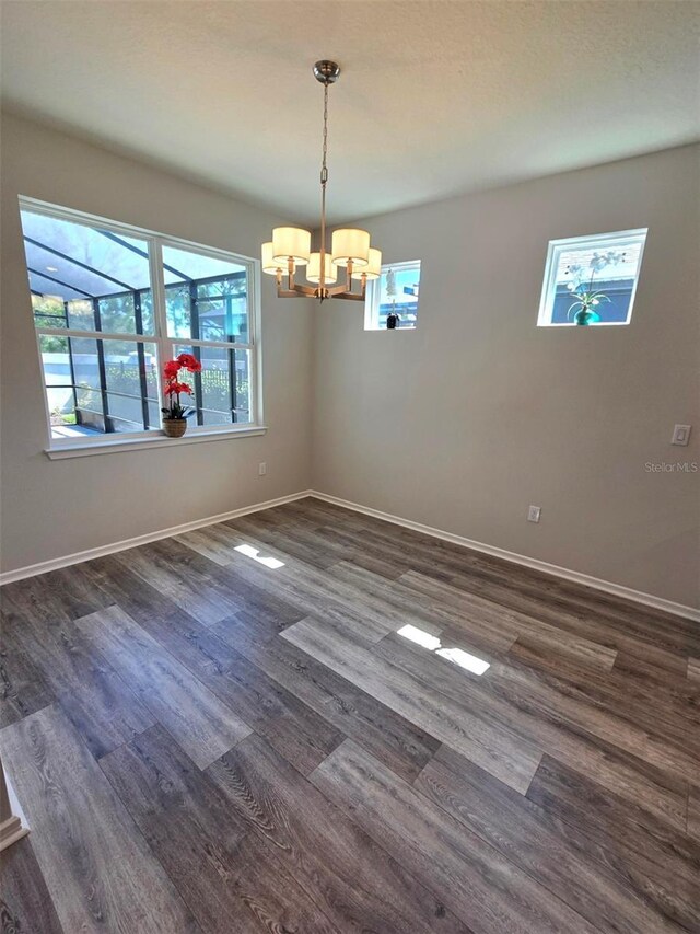 6129 Citrus Grove Ct, Saint Cloud, FL 34771 - unfurnished room featuring a chandelier, baseboards, and dark wood-type flooring