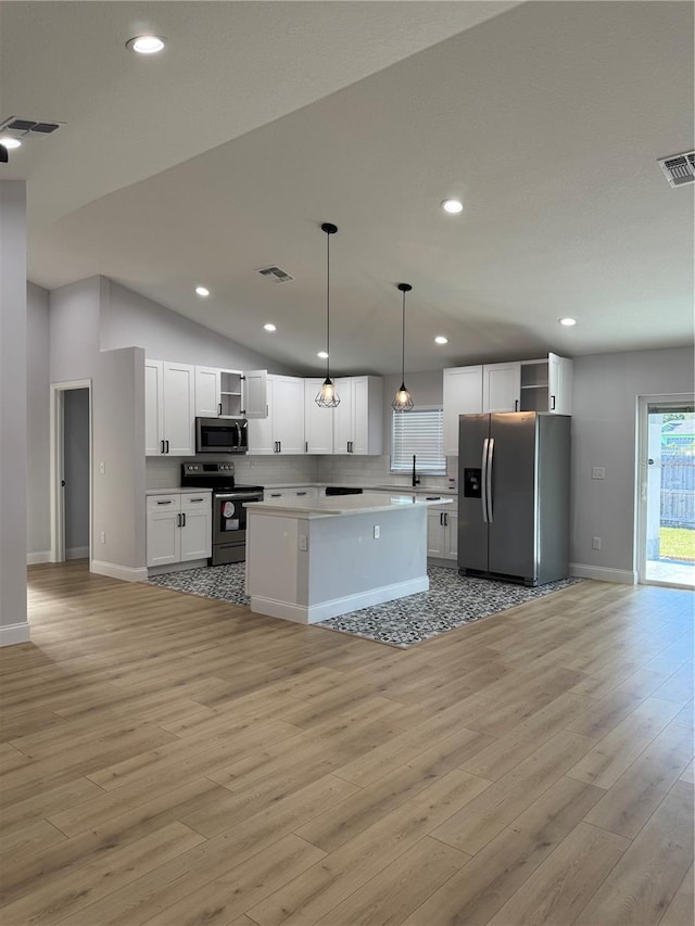468 Marion Oaks Blvd, Ocala, FL 34473 - kitchen with appliances with stainless steel finishes, open shelves, light wood-style floors, white cabinets, and vaulted ceiling