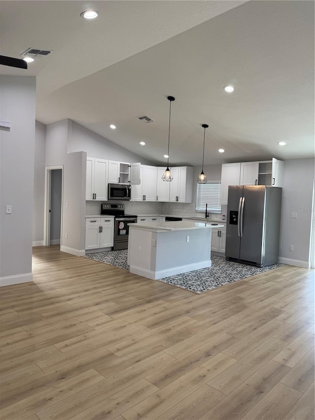 468 Marion Oaks Blvd, Ocala, FL 34473 - kitchen featuring appliances with stainless steel finishes, open shelves, light wood-type flooring, white cabinetry, and a center island
