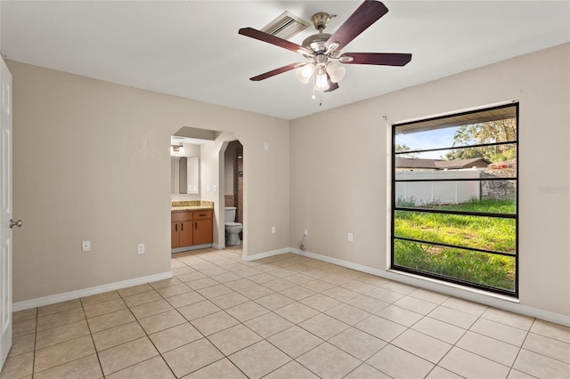 22 Hillcrest Dr, Babson Park, FL 33827 - unfurnished room with arched walkways, a ceiling fan, baseboards, and light tile patterned floors