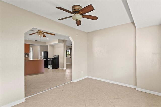 22 Hillcrest Dr, Babson Park, FL 33827 - unfurnished living room with a ceiling fan, light tile patterned floors, baseboards, and arched walkways