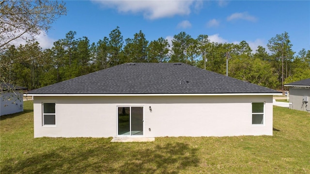 9825 N Swanee Ter, Dunnellon, FL 34433 - rear view of house featuring a yard, roof with shingles, and stucco siding