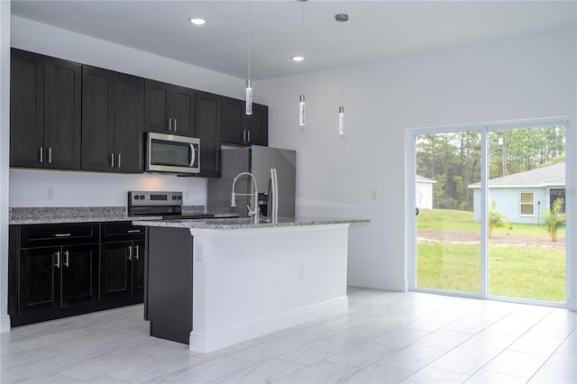 9825 N Swanee Ter, Dunnellon, FL 34433 - kitchen with appliances with stainless steel finishes, dark cabinets, a kitchen island with sink, light stone counters, and recessed lighting